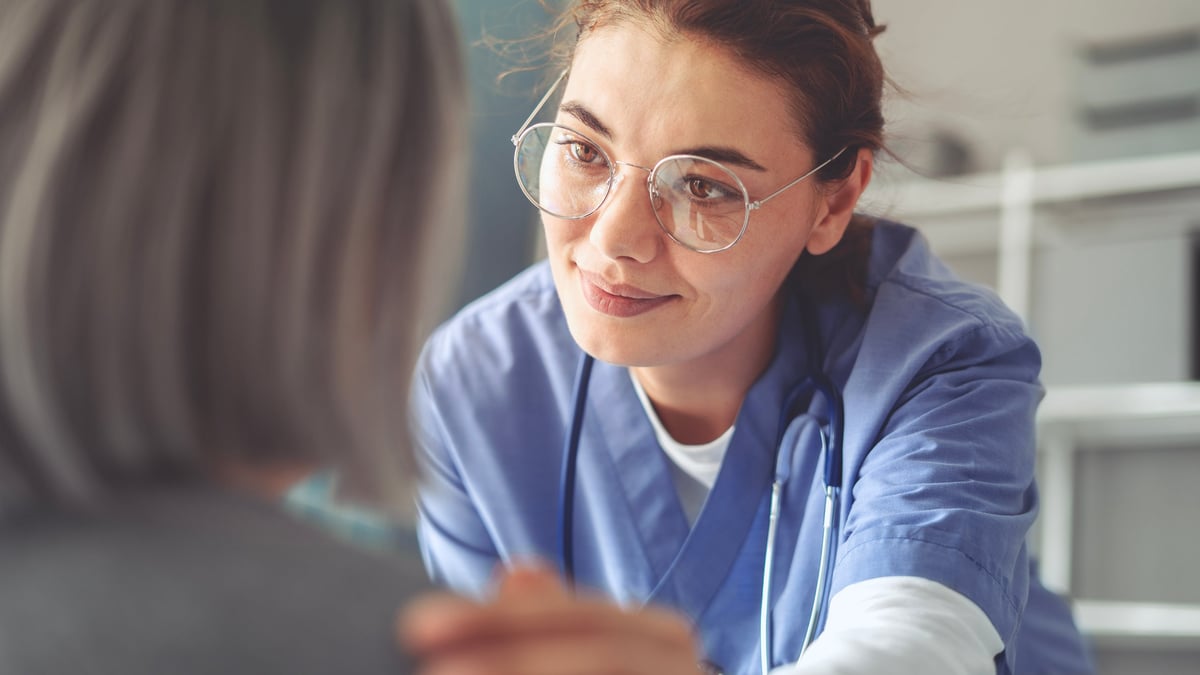 A healthcare professional caring for and comforting an older patient