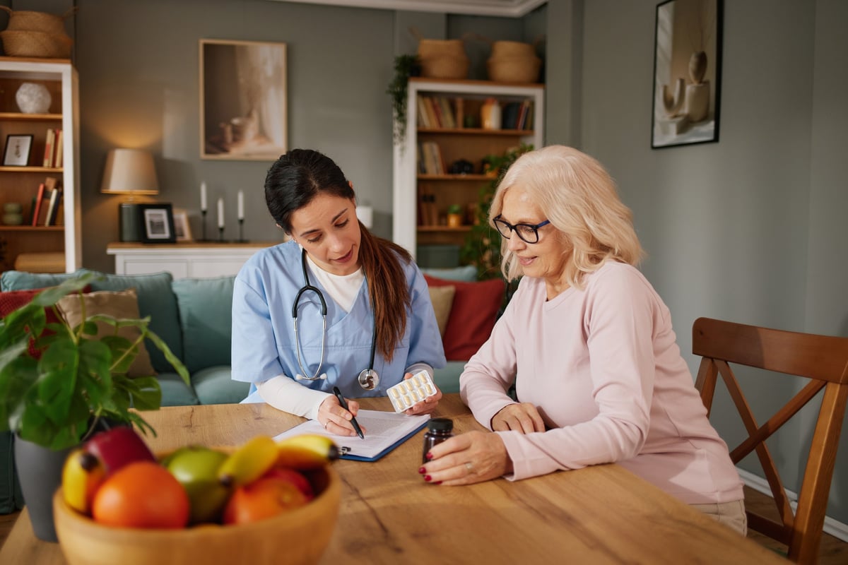 A nurse talking with an older patient during a home visit